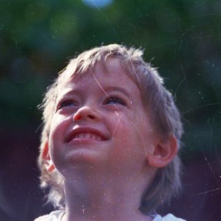 Joyful child laughing in sunlight.