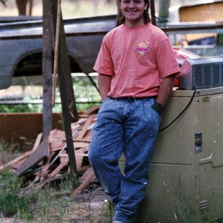 Person smiling outdoors near a generator.