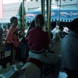 Classic carousel with seated riders enjoying amusement park.