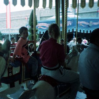 Classic carousel with seated riders enjoying amusement park.