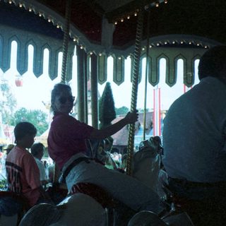 Carousel ride with people seated inside.