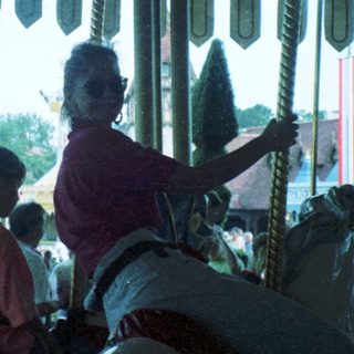 Carousel ride with people seated inside.