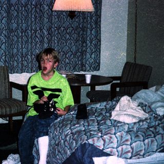Boy in hotel room holding toy gun.