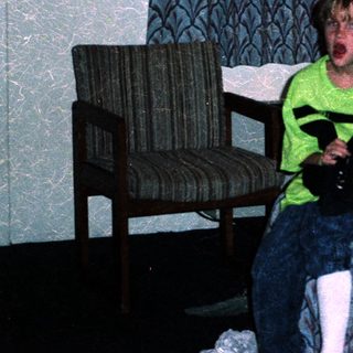 Boy in hotel room holding toy gun.