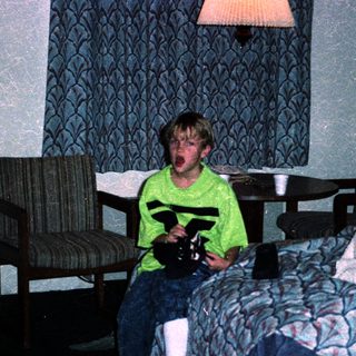 Boy in hotel room holding toy gun.