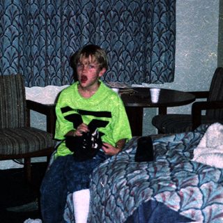 Boy in hotel room holding toy gun.