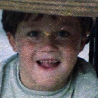Boy smiling at table with food.