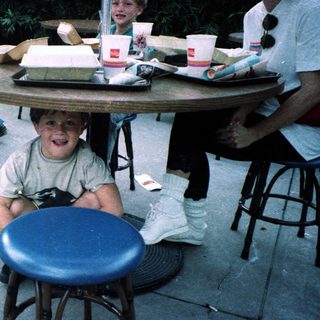 Boy smiling at table with food.