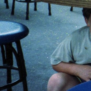 Family enjoying fast food outdoors at picnic tables.