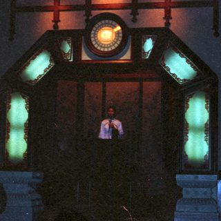 Vintage clock with illuminated green glass panels.