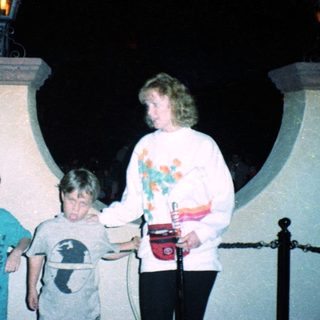 Family posing under illuminated lampposts at night.