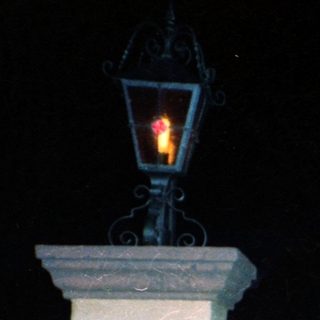 Family posing under illuminated lampposts at night.