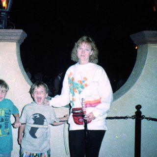 Family posing with amusement park ride lights.
