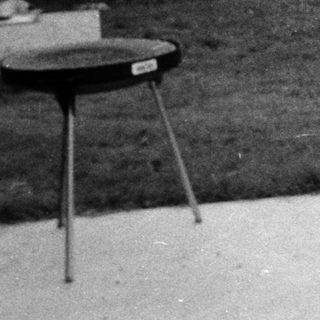 Woman smiling outdoors in 1960s-style blouse.