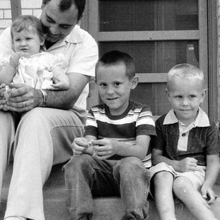 Family portrait with father and four children on porch.