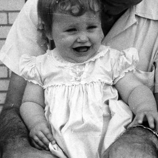 A man holding a laughing young child outdoors.