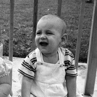 Two young children laughing together outdoors.