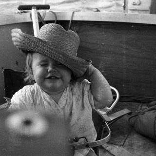 Child smiling while seated in a boat.