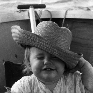 Child smiling while seated in a boat.