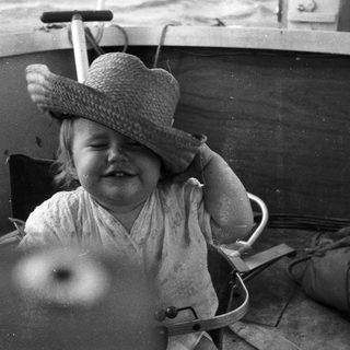 Child smiling while seated in a boat.