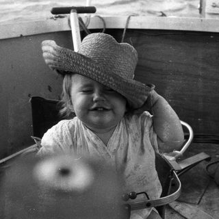 Child smiling while seated in a boat.