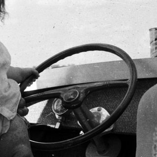 Happy man holding smiling child in vintage car.