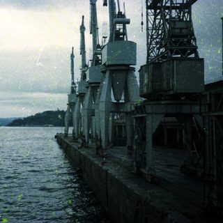 Industrial dock with cranes by waterfront.