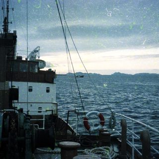 Maritime vessel on open sea near islands.