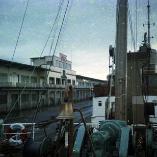 Maritime port with docked ships and industrial buildings.