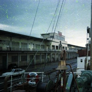 Maritime port with docked ships and industrial buildings.