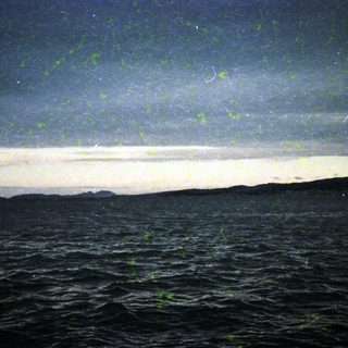 Starry night sky over dark ocean waves.