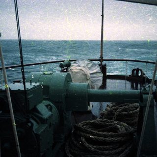 Maritime bridge with naval gun and ocean view.