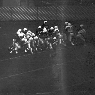 Football players in action during a snap.