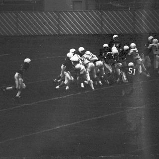 Football players in action during a snap.