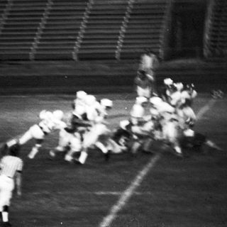 Blurred action shot of football players in motion.
