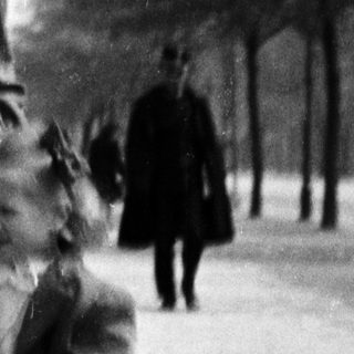 A woman leads a young child along a path.
