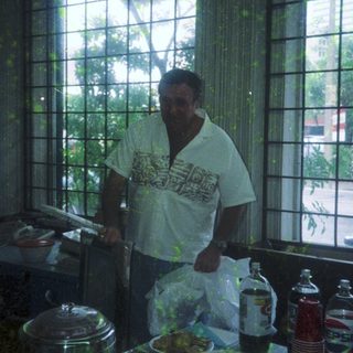 Man preparing food in a kitchen near large windows.