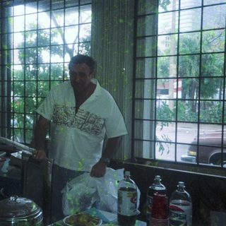 Man preparing food in a kitchen near large windows.
