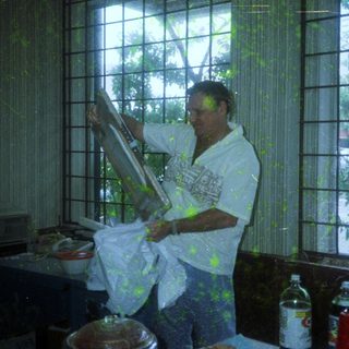 Man painting window sill indoors with paintbrush.