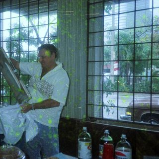 Man painting window sill indoors with paintbrush.