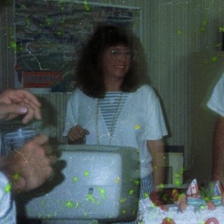 People cutting and serving cake indoors.