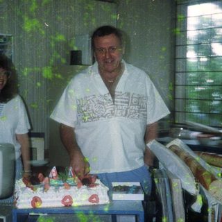 Two people celebrating a birthday with cake.