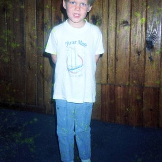 Young boy wearing "First Mate" T-shirt and jeans.