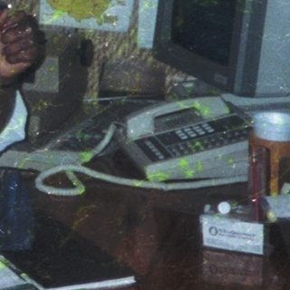 Person in office setting eating cake at desk.