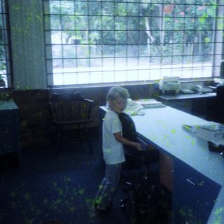Child standing in messy, painted room.
