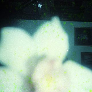 Blurry reflection of two people through rain-streaked glass.