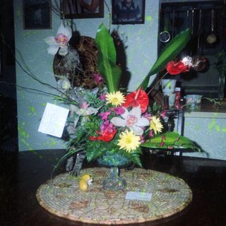 Vibrant floral arrangement on decorative mosaic table base.