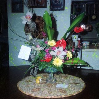 Vibrant floral arrangement on decorative mosaic table base.