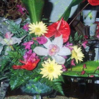 Vibrant floral arrangement on decorative mosaic table base.