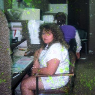 Two people working in dimly lit office cubicles.